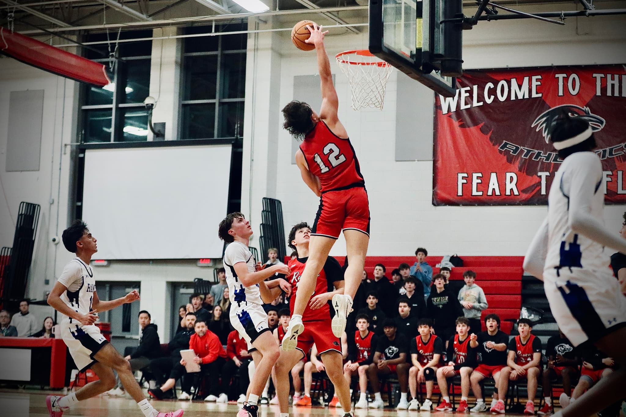 Player #12 rises for the dunk